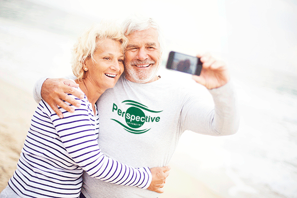 Vision therapy for adults over 60 - couple in their 60s embracing and taking a selfie with a smartphone